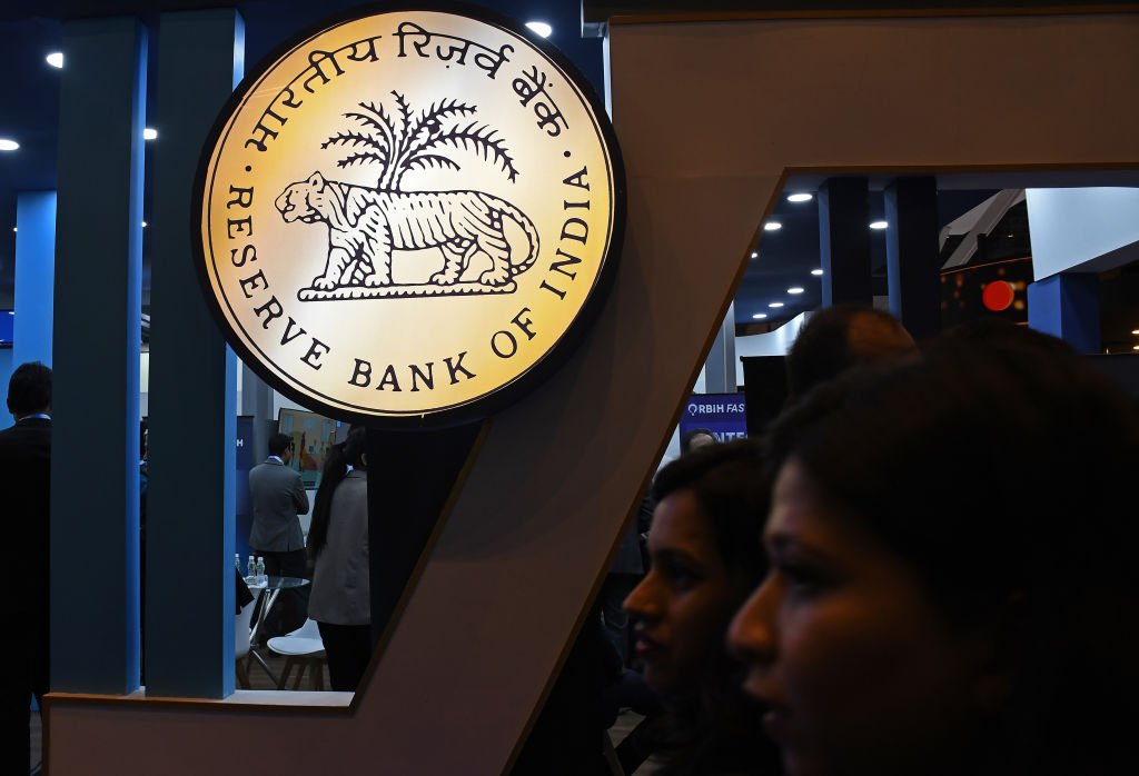 Women (silhouetted) walk past Reserve Bank of India (RBI)