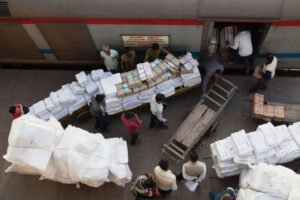 Porters loading baggage into the goods carriage of an express train at Railway Station.