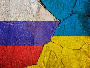 Flag of Ukraine and Russia on a wall with cracks.