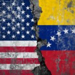 American and Venezuelan flags painted on a cracked concrete wall showing the deep divide and separation between USA and Venezuela