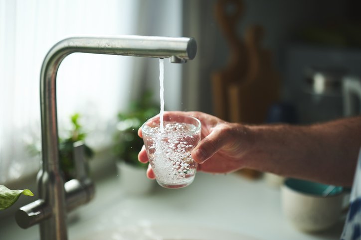Hand Holding Glass Under Tap for Fresh Drinking Water at Home